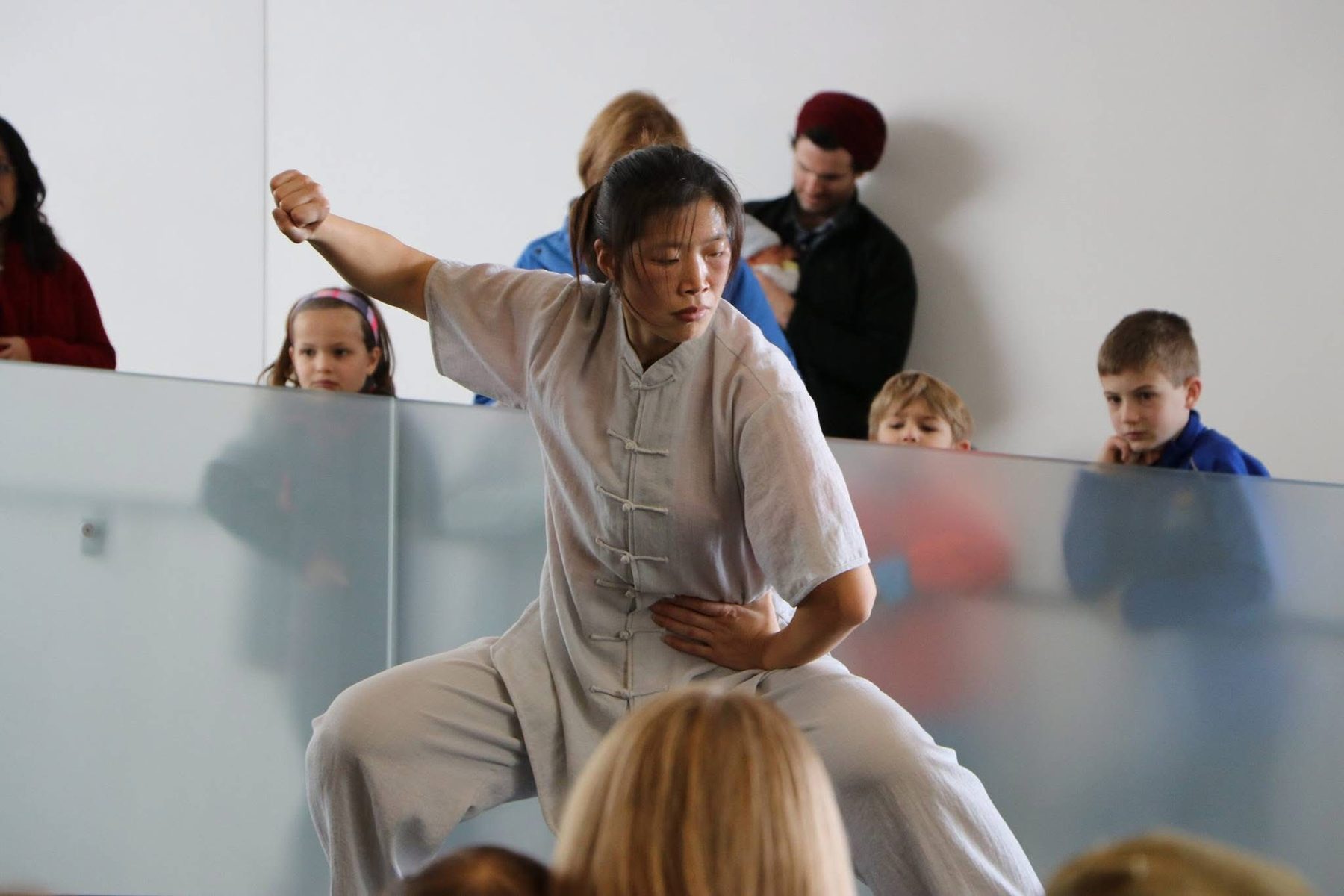 Master Chen Huixian demonstrating a low Chen Taijiquan posture before an audience at the Nelson-Atkins Museum of Art